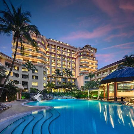 Paradox Singapore Merchant Court At Clarke Quay Экстерьер фото The photo shows a luxurious hotel building, featuring multiple stories and a modern architectural design. In front of the hotel, there is a large, inviting swimming pool that is illuminated in a vibrant blue hue, suggesting it may be an evening setti