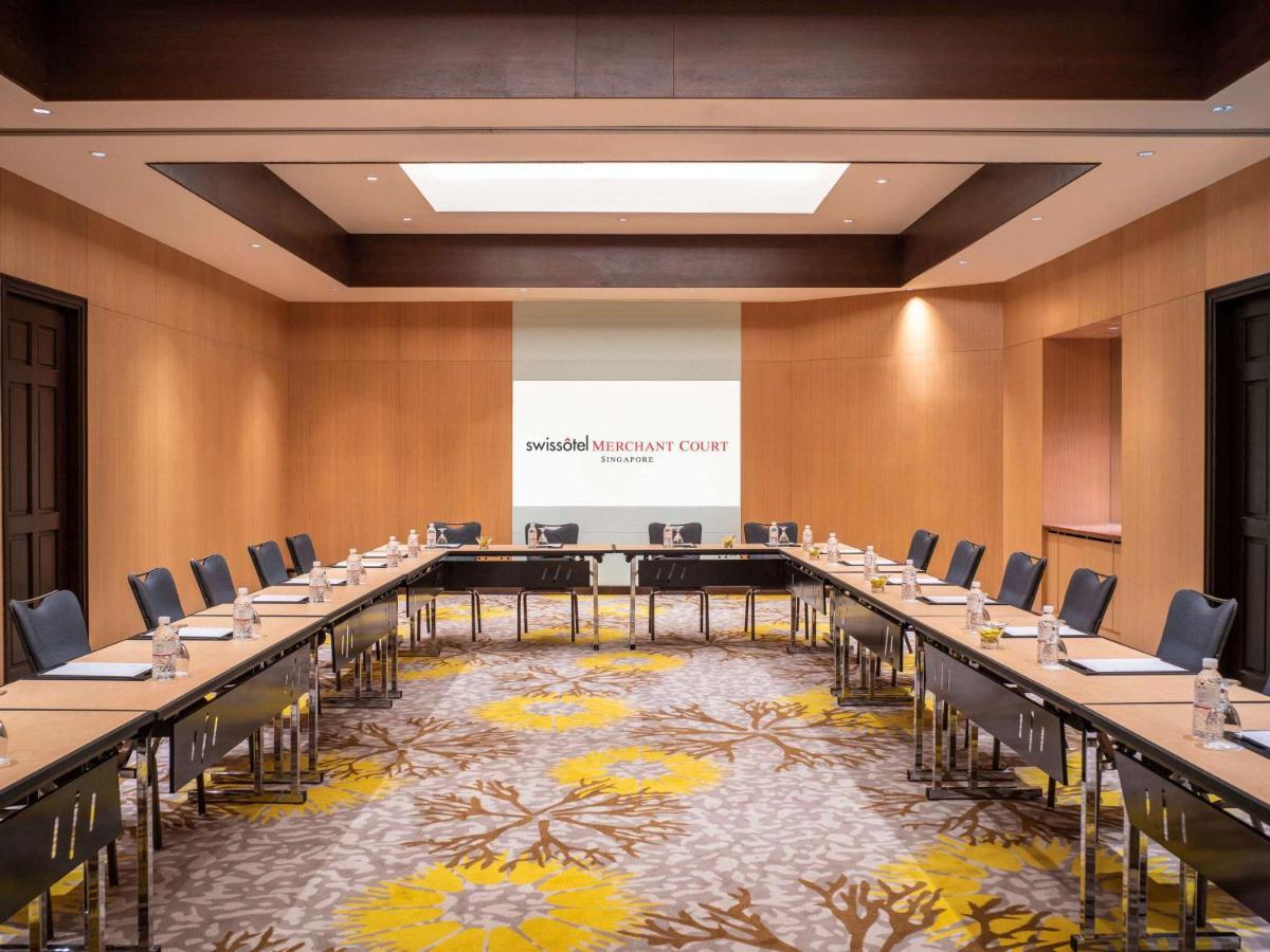 Paradox Singapore Merchant Court At Clarke Quay Экстерьер фото The image shows a professional conference room designed for meetings. It features a large rectangular arrangement of tables with black chairs surrounding them. The walls are made of light-colored wood, contributing to a modern and sophisticated atmos