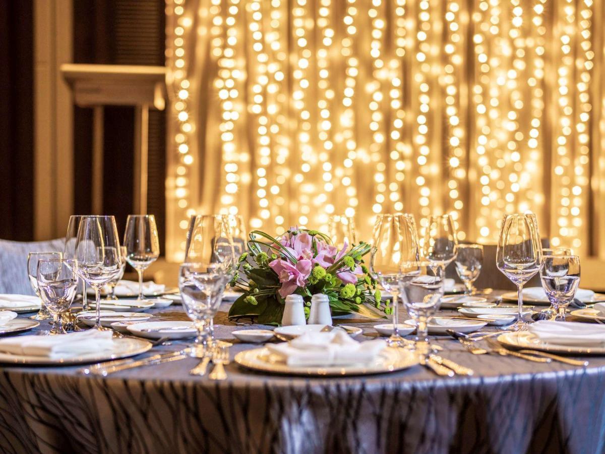 Paradox Singapore Merchant Court At Clarke Quay Экстерьер фото The image shows a beautifully set dining table, elegantly arranged for a special event or celebration. The table is covered with a stylish cloth, and there are several plates, glasses, and utensils neatly placed around it. In the center, there's a fl