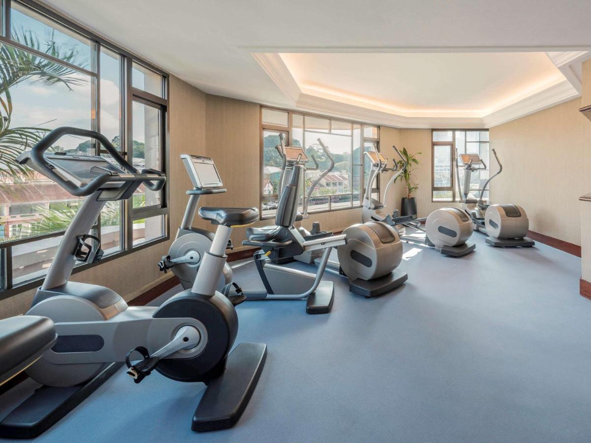 Paradox Singapore Merchant Court At Clarke Quay Экстерьер фото The photo shows a gym or fitness room equipped with various exercise machines. There are stationary bikes, elliptical trainers, and a multi-gym machine for strength training. Large windows allow natural light to fill the space, offering a view of the