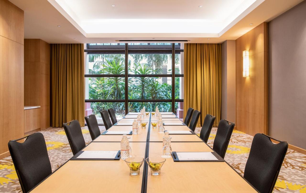 Paradox Singapore Merchant Court At Clarke Quay Экстерьер фото The photo shows a modern conference room with a long rectangular table set up for a meeting. The table is topped with water bottles and small decorative bowls, possibly containing snacks or centrepieces. The room features large windows that provide a