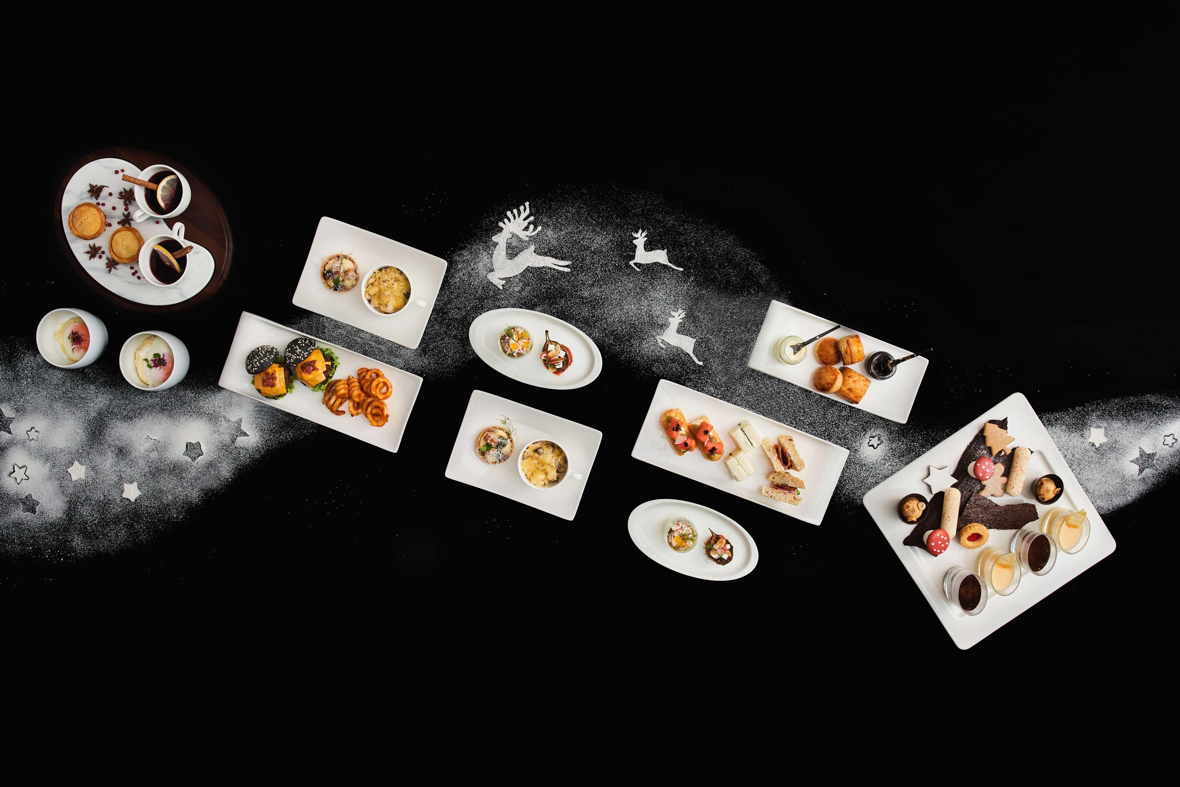 Paradox Singapore Merchant Court At Clarke Quay Экстерьер фото The photo features an artistic arrangement of various gourmet dishes presented on white plates against a dark background. The dishes include a mix of desserts and appetizers, showcasing vibrant colors and intricate designs. Some plates contain small 