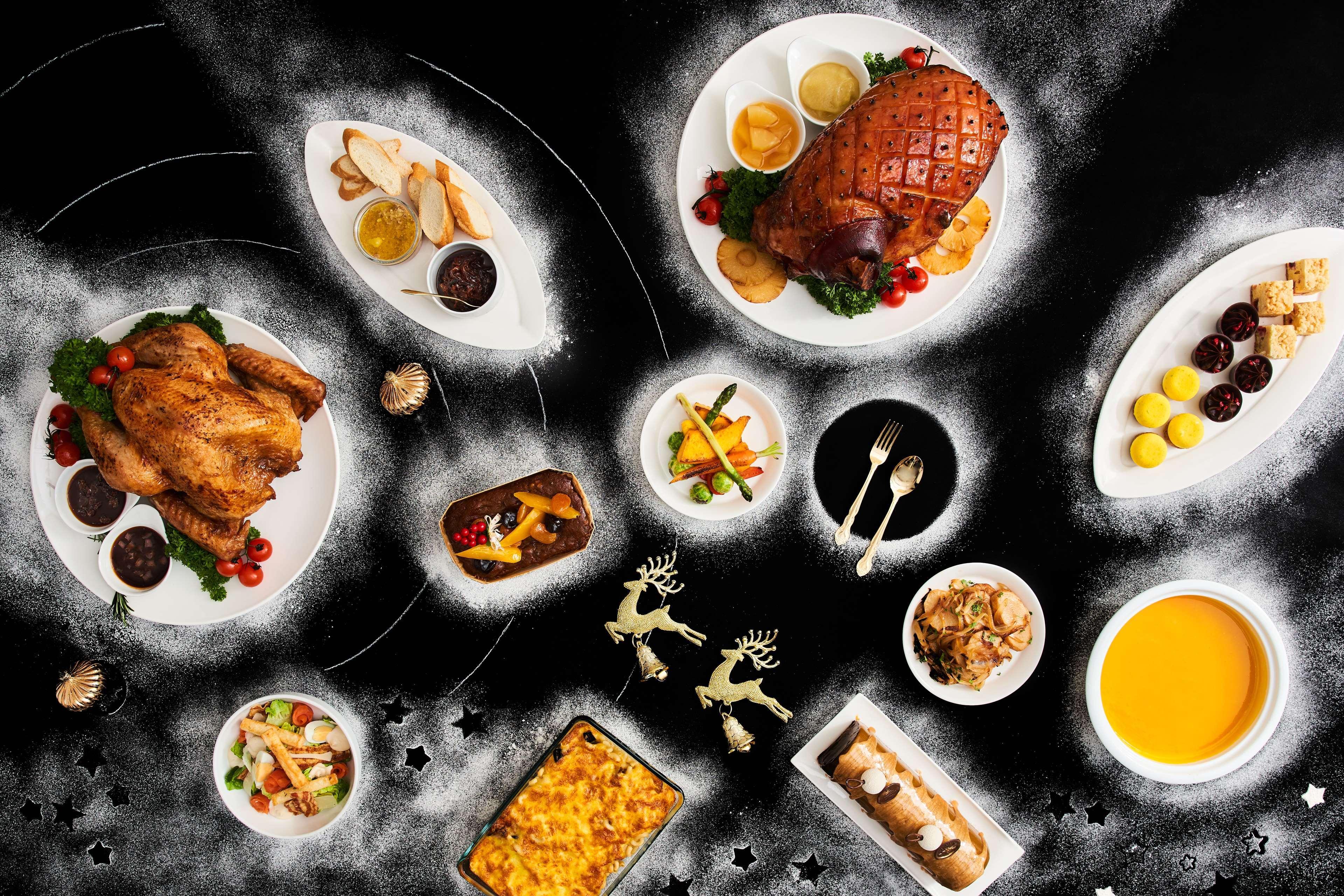 Paradox Singapore Merchant Court At Clarke Quay Экстерьер фото The photo depicts a variety of dishes arranged artistically on a dark backdrop. In the center, there is a large roasted ham, garnished with herbs. Surrounding it are several plates featuring a whole roasted chicken, a colorful vegetable medley, and a