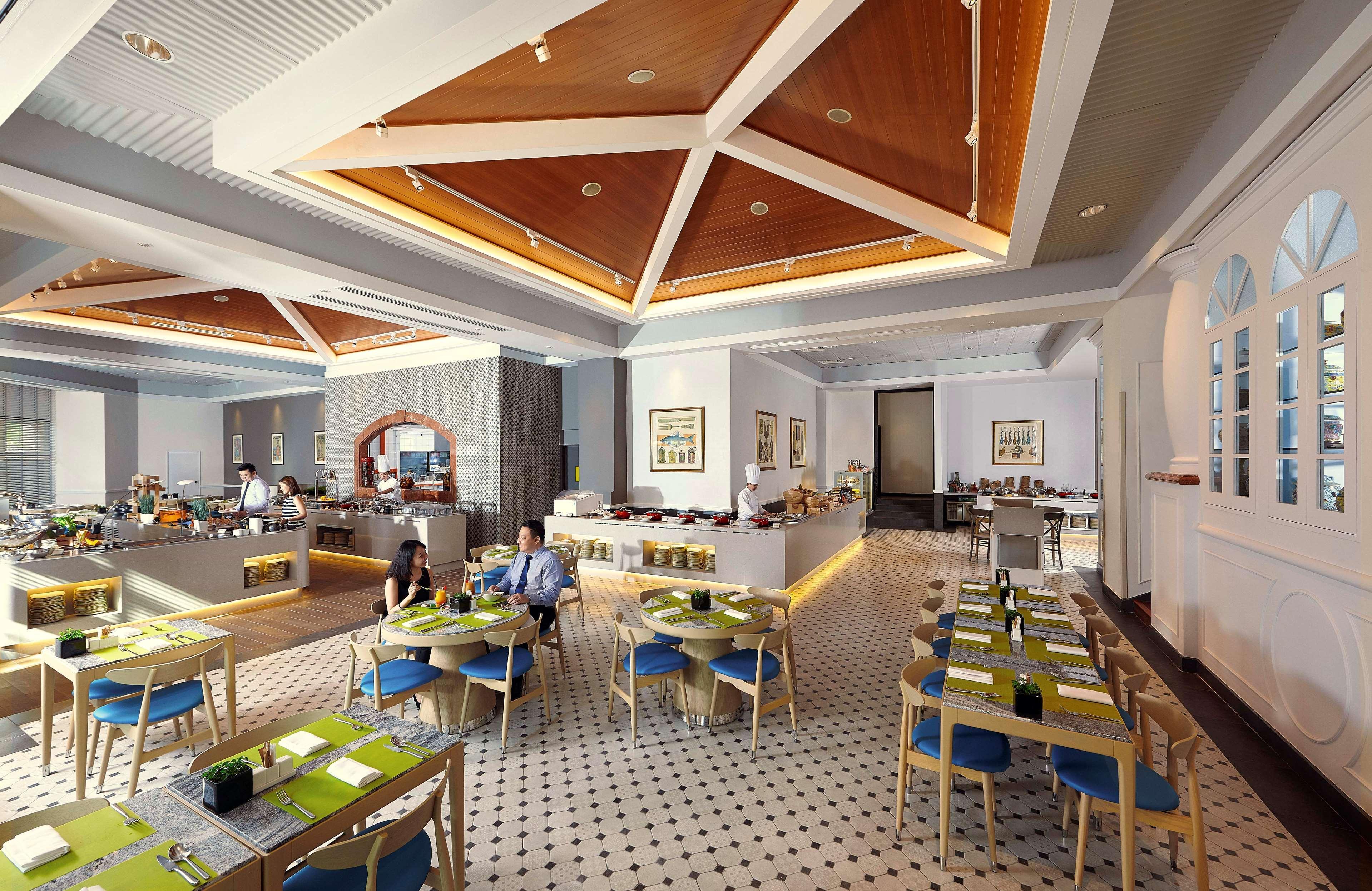 Paradox Singapore Merchant Court At Clarke Quay Экстерьер фото The photo shows a modern restaurant interior with a spacious layout. The ceiling features a geometric wooden design, adding a touch of elegance. The floor has a checkered pattern, contributing to the decor's stylish feel. 

There are several tables a