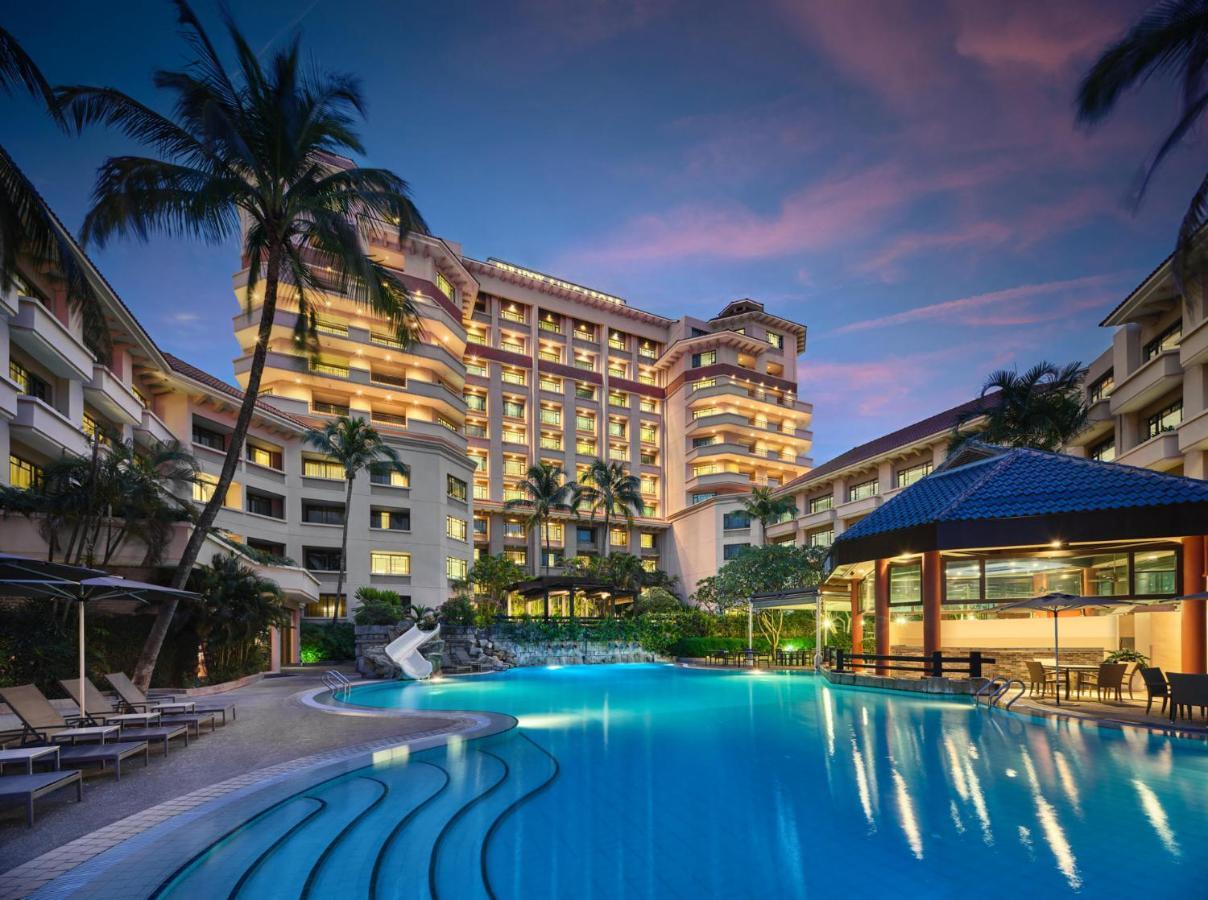 Paradox Singapore Merchant Court At Clarke Quay Экстерьер фото The photo shows a luxurious hotel building, featuring multiple stories and a modern architectural design. In front of the hotel, there is a large, inviting swimming pool that is illuminated in a vibrant blue hue, suggesting it may be an evening setti