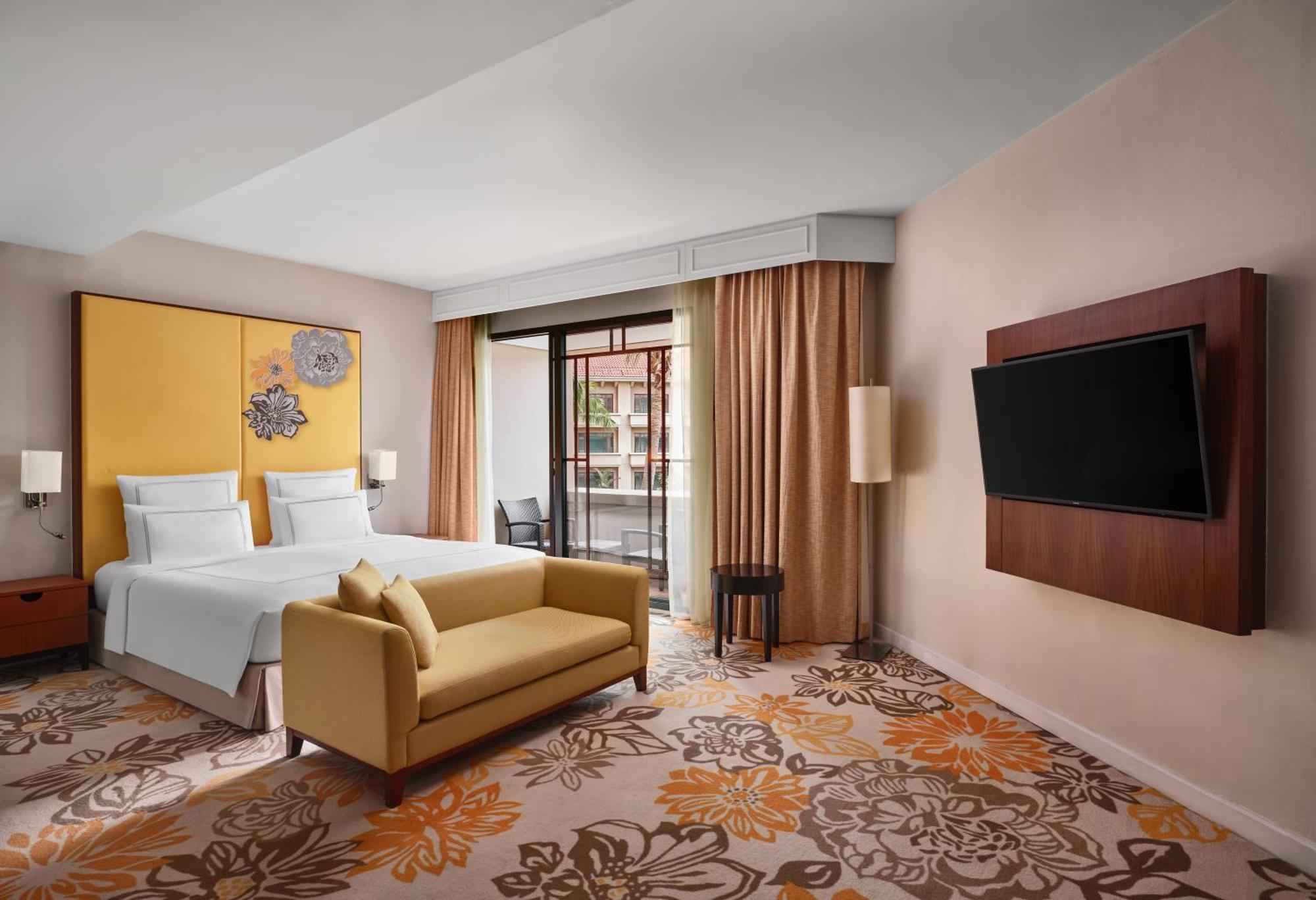 Paradox Singapore Merchant Court At Clarke Quay Экстерьер фото The photo shows a modern hotel room featuring:

- A queen or king-sized bed with white bedding against a bright yellow wall.
- A cozy yellow sofa placed in front of the bed.
- A plush carpet with floral designs in warm colors.
- Large windows with be
